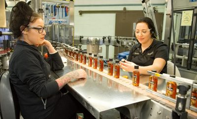 Two female employees inspecting bottles of Tuaca
