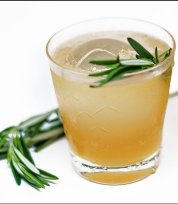 Closeup of a whiskey and ginger cocktail with garnish