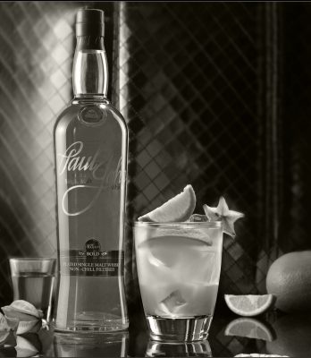 Black and white Paul John Single Malt sour cocktail with lime and starfruit garnish