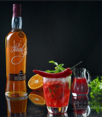 Paul John Single Malt red cocktail with orange and pepper garnish