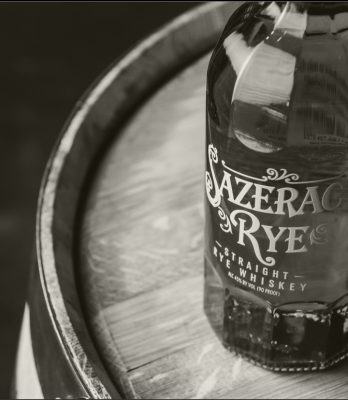Black and white closeup of Sazerac Rye bottle on barrel