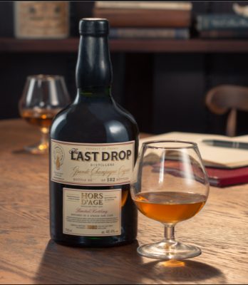 Last Drop bottle and neat pour in glencairn glass on table with notebook in the background