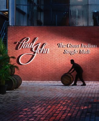 Download Front of Paul John Distillery with man rolling barrel