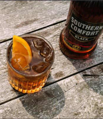 Download Closeup of a Southern Comfort Black cocktail and bottle on wood table