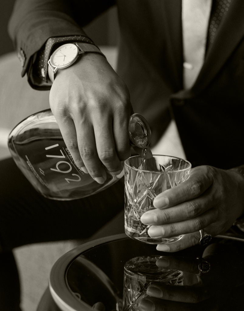 A 750ml bottle of Small Batch 1792 Bourbon Whiskey being poured into a Whiskey glass