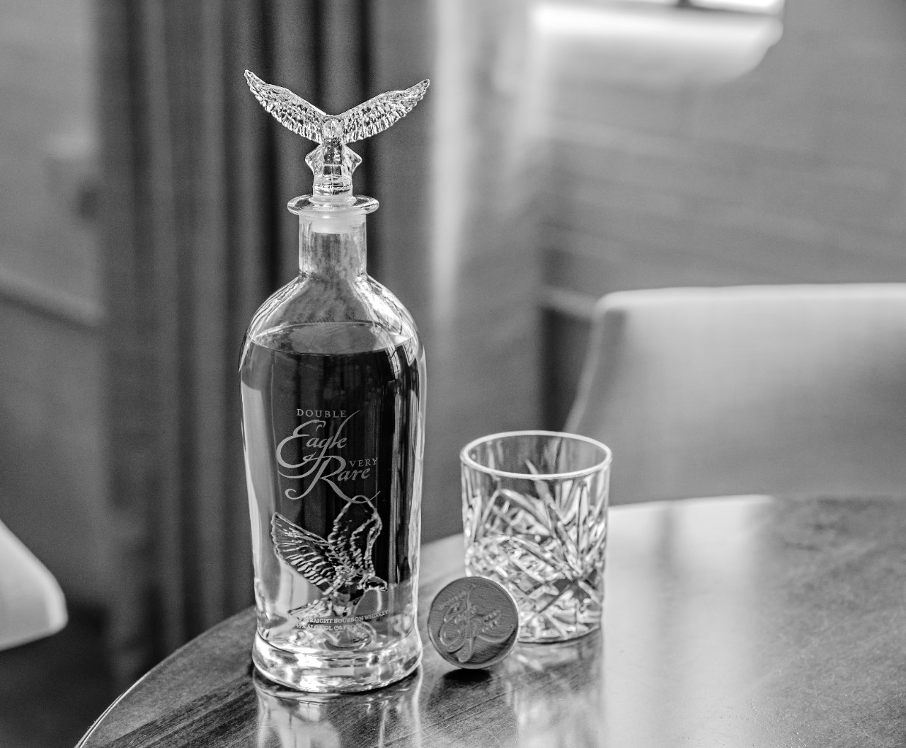 Double Eagle Very Rare Bottle and crystal glass on table in black and white