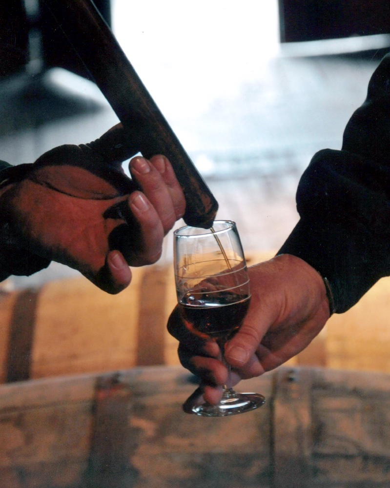 Person pouring taste of whiskey into glass