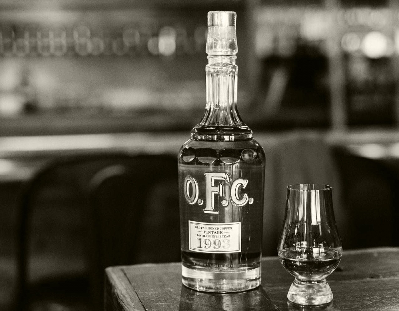 Black and white OFC bottle and glass on table