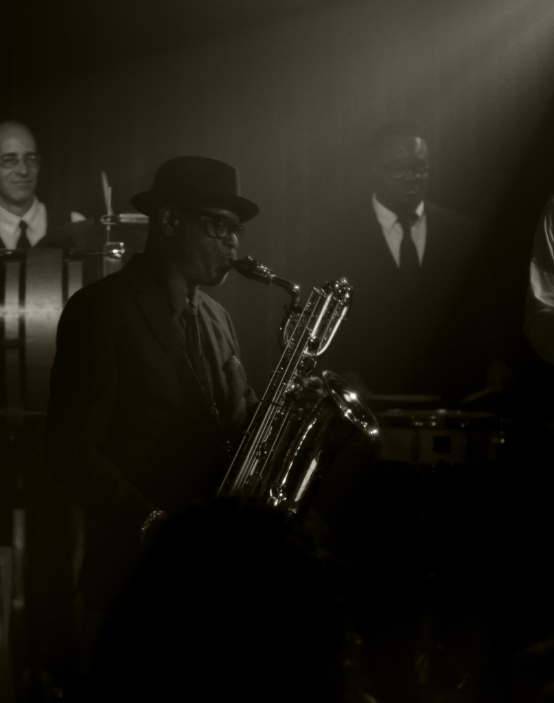 A man playing a saxophone with a band