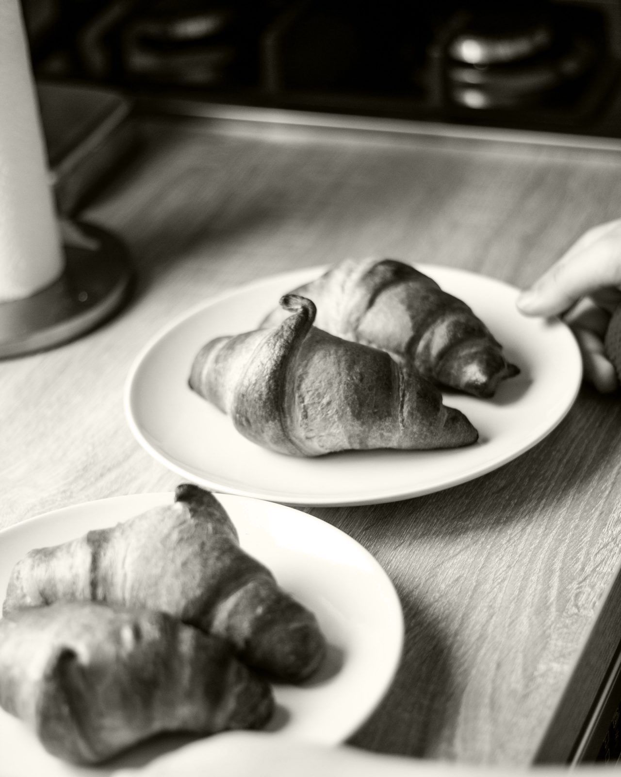 Black and white table with two plates of two croissants on each