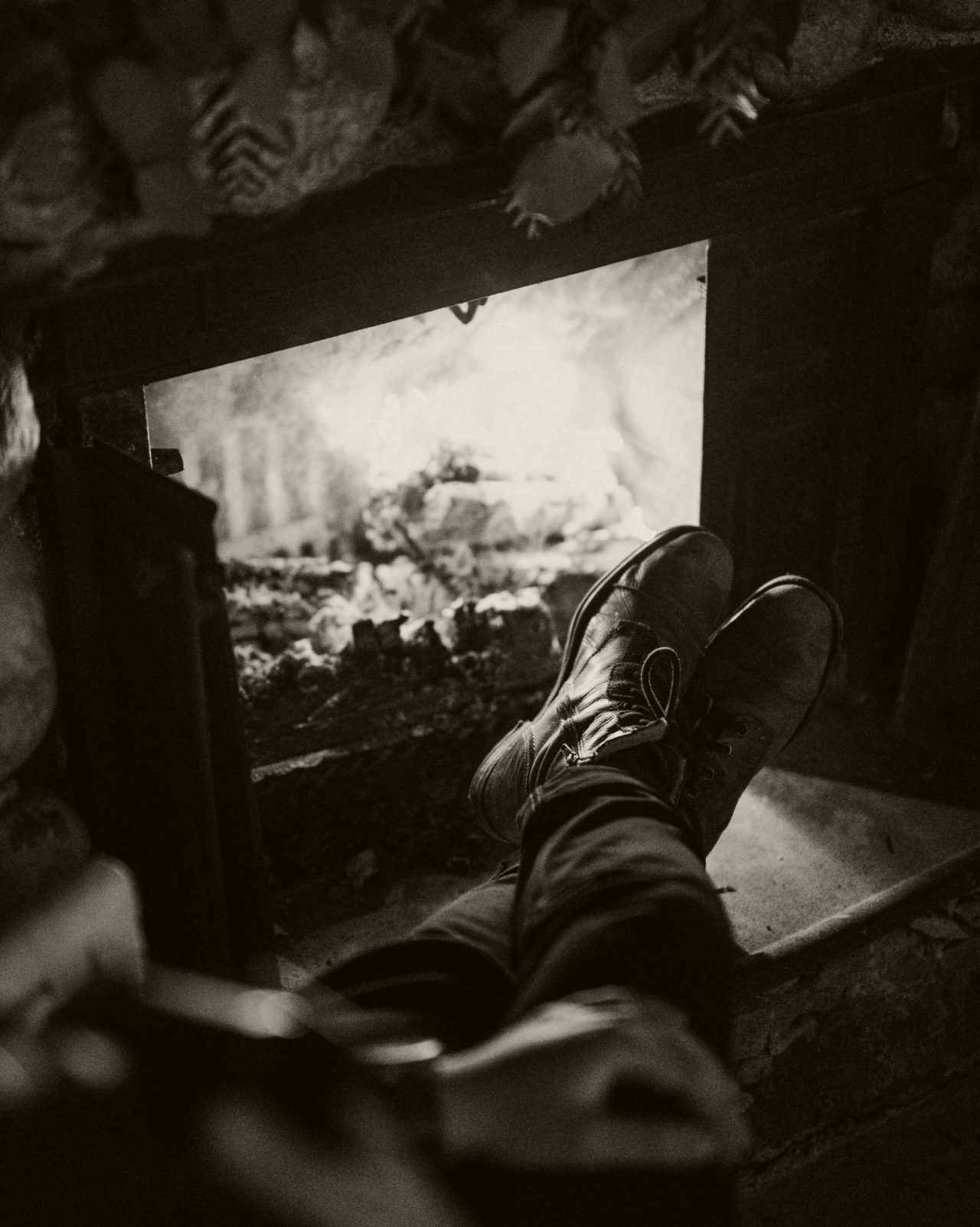 Black and white male sitting by fire