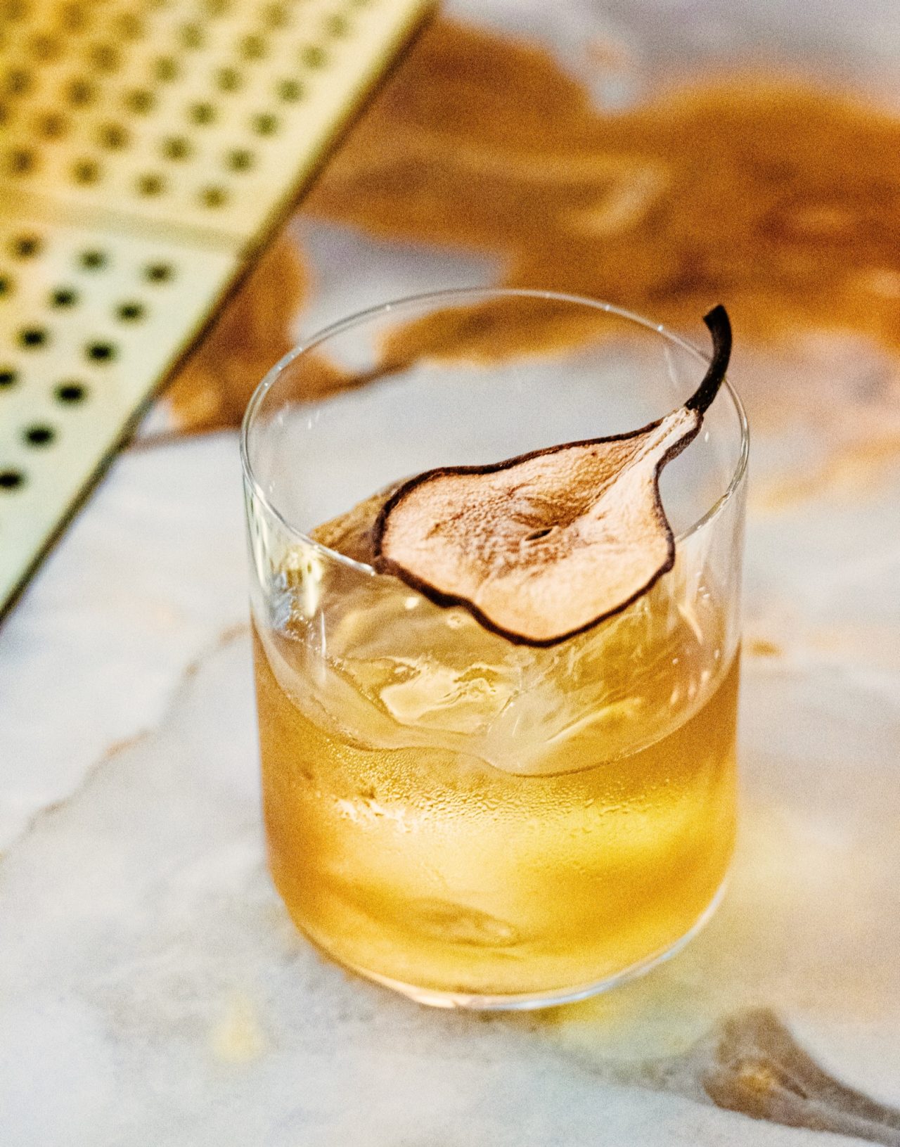 Artisanal cocktail on table with crisp apple slice